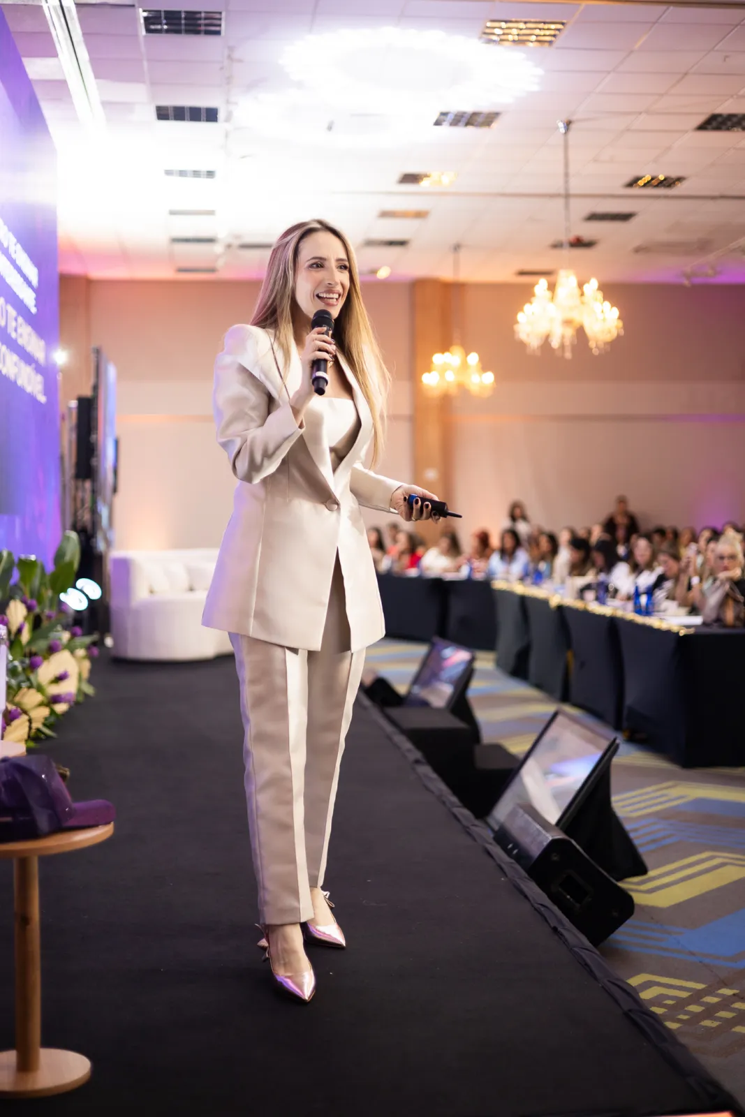 Tinara Fava palestrando com microfone no palco